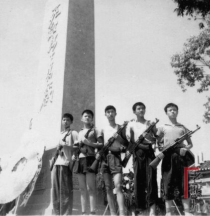 1967年武斗停息后，在刚建成的重庆29中毛泽东主义战斗团死难同学“烈士墓”碑下，几个中学生手持冲锋枪留影，表示“挥泪继承烈士志，誓将遗愿化宏图”的“决心”
