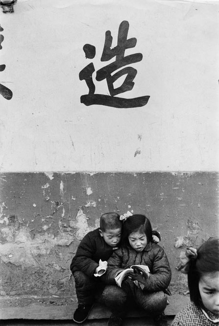 看小人书入了迷的小孩。北京 1957年