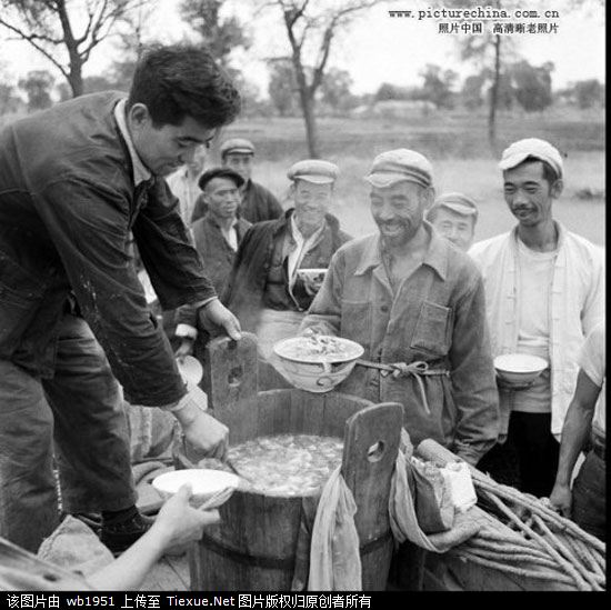 1958年，北京海淀人民公社青龙桥工作站提出“吃饭不花钱，努力搞生产”，一日三餐集体安排统做统吃。图为社员排队打饭
